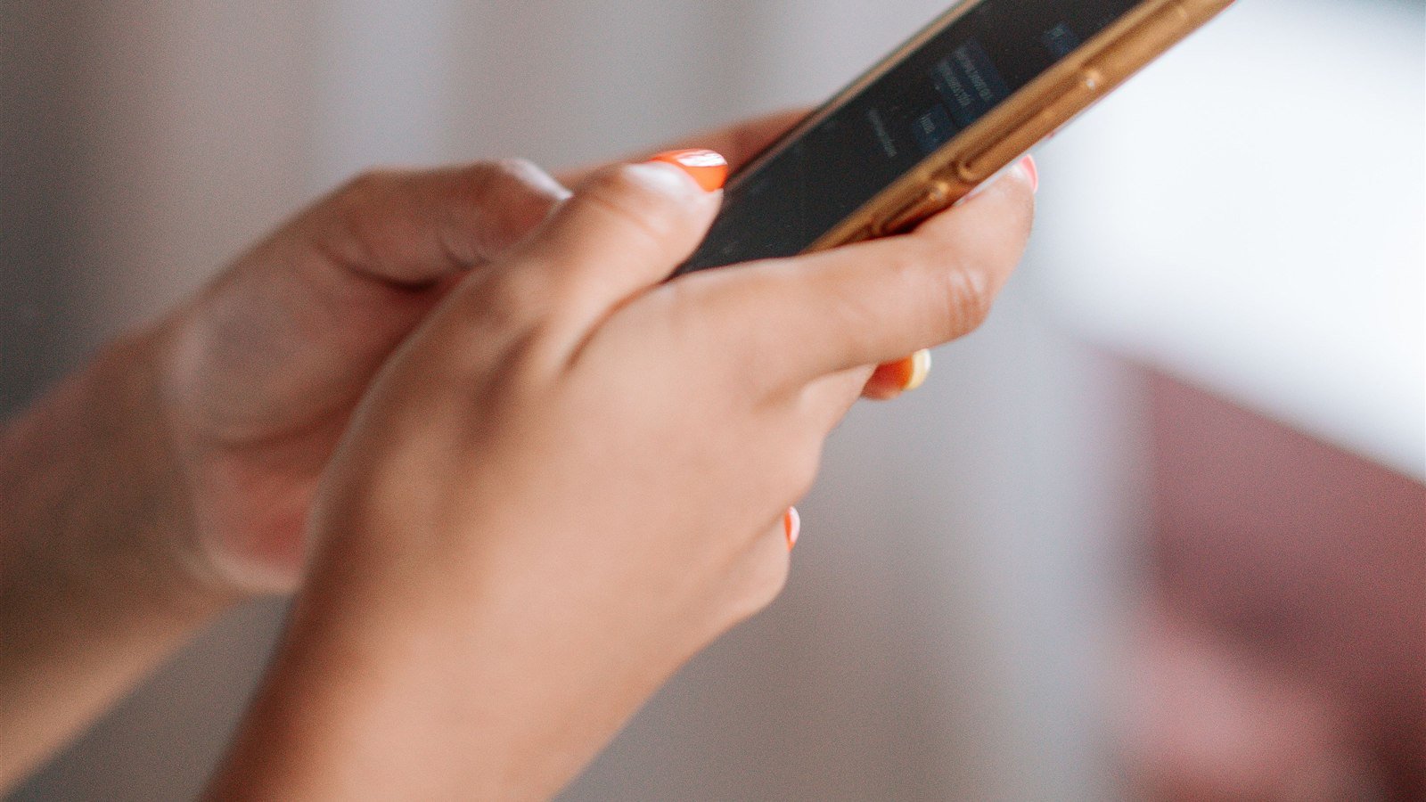 Mulher escrevendo mensagem de cobrança educada para cliente no celular