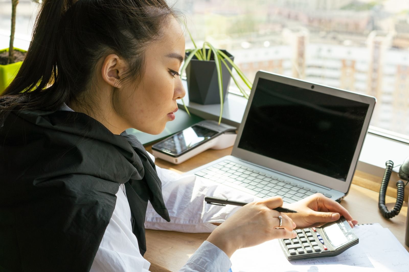 Mulher calculando recibos no computador, tentando entender se autônoma precisa pagar imposto de renda