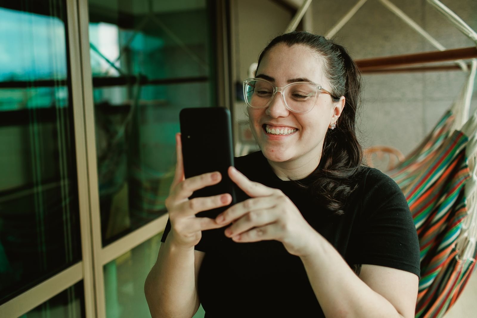 Mulher transferindo dinheiro pelo celular, aplicando o método de como não gastar o dinheiro do mês bom