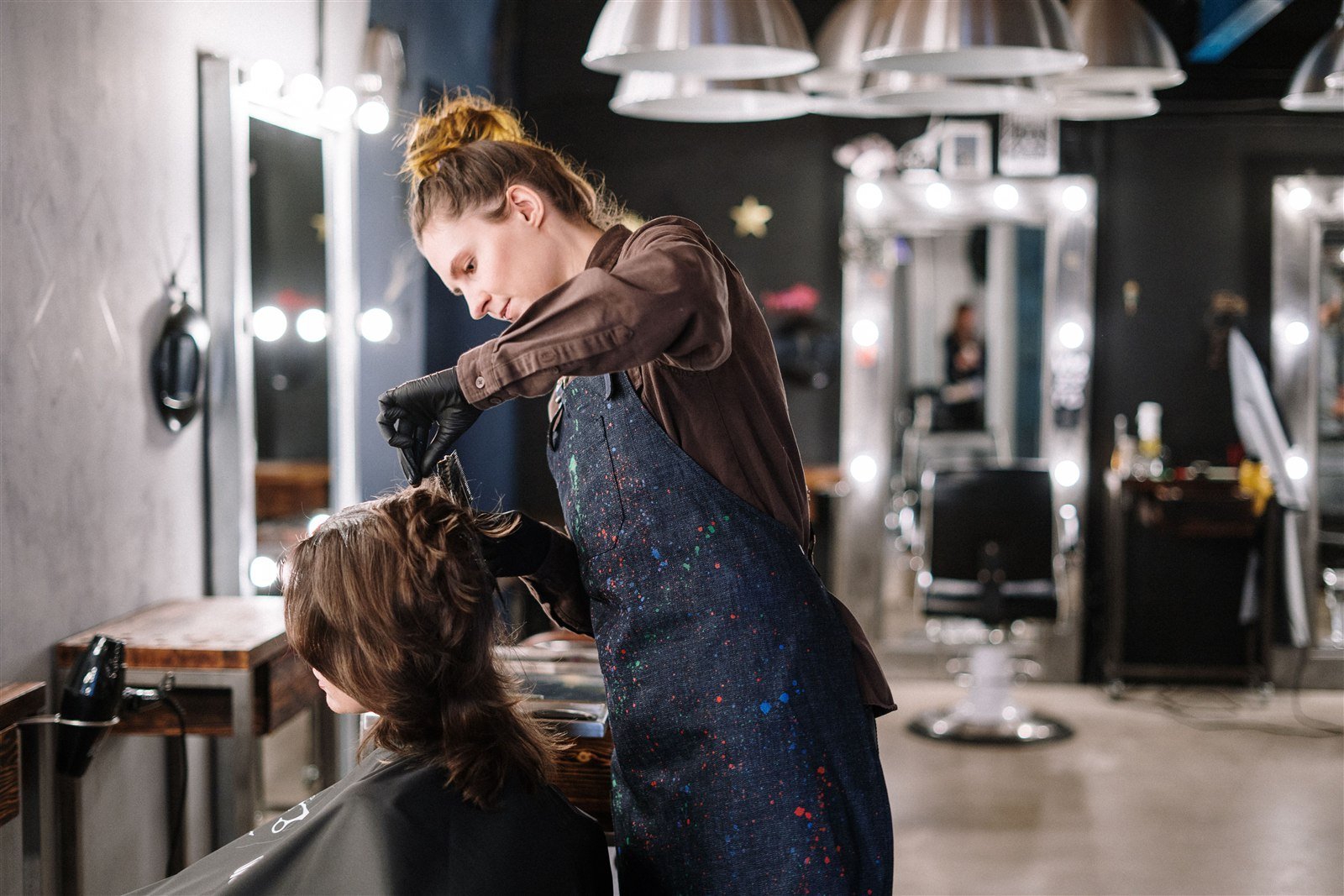 Cabeleireira atendendo cliente com secador de cabelo em salão de beleza
