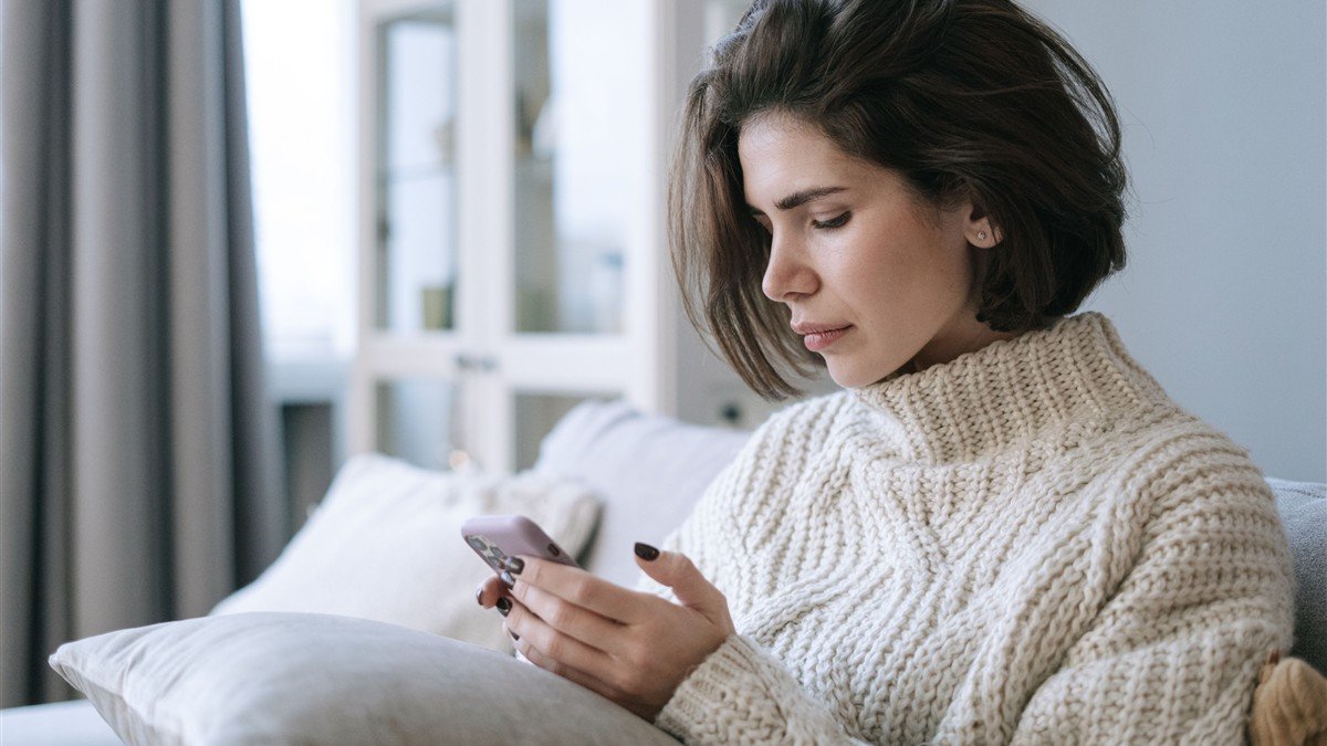 Mulher usando aplicativo de controle financeiro no celular
