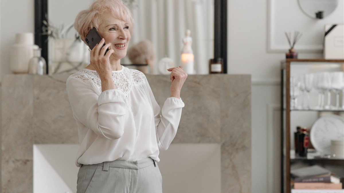 Mulher madura sorrindo tranquila planejando o futuro financeiro