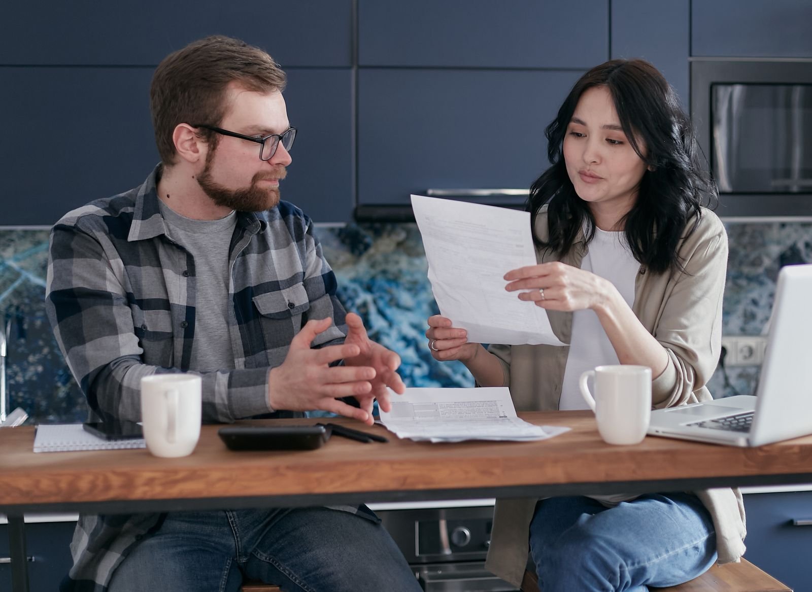 Casal revisando extrato bancário e contas de casa no notebook