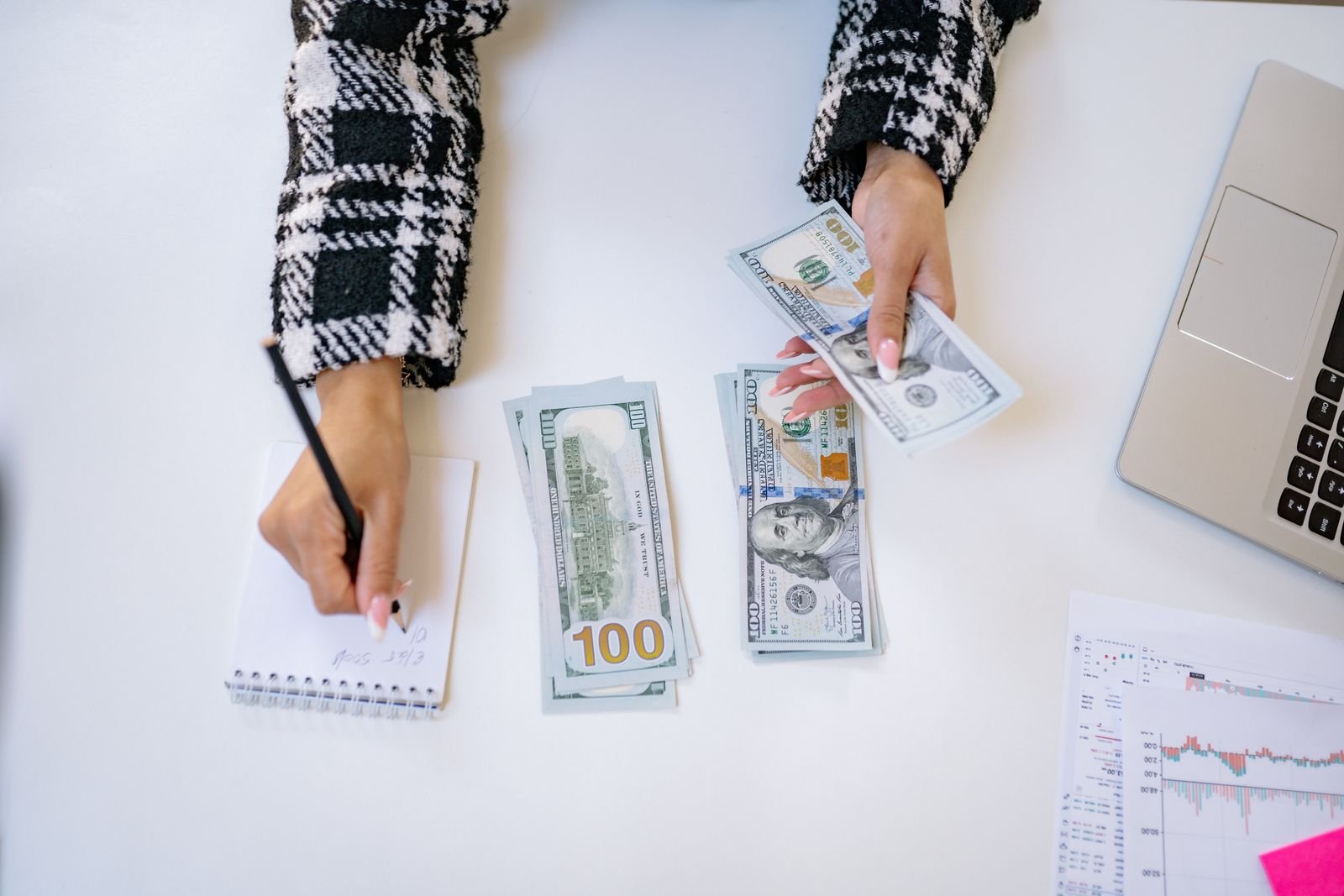 Revendedora calculando o lucro das vendas do mês com calculadora e catálogo