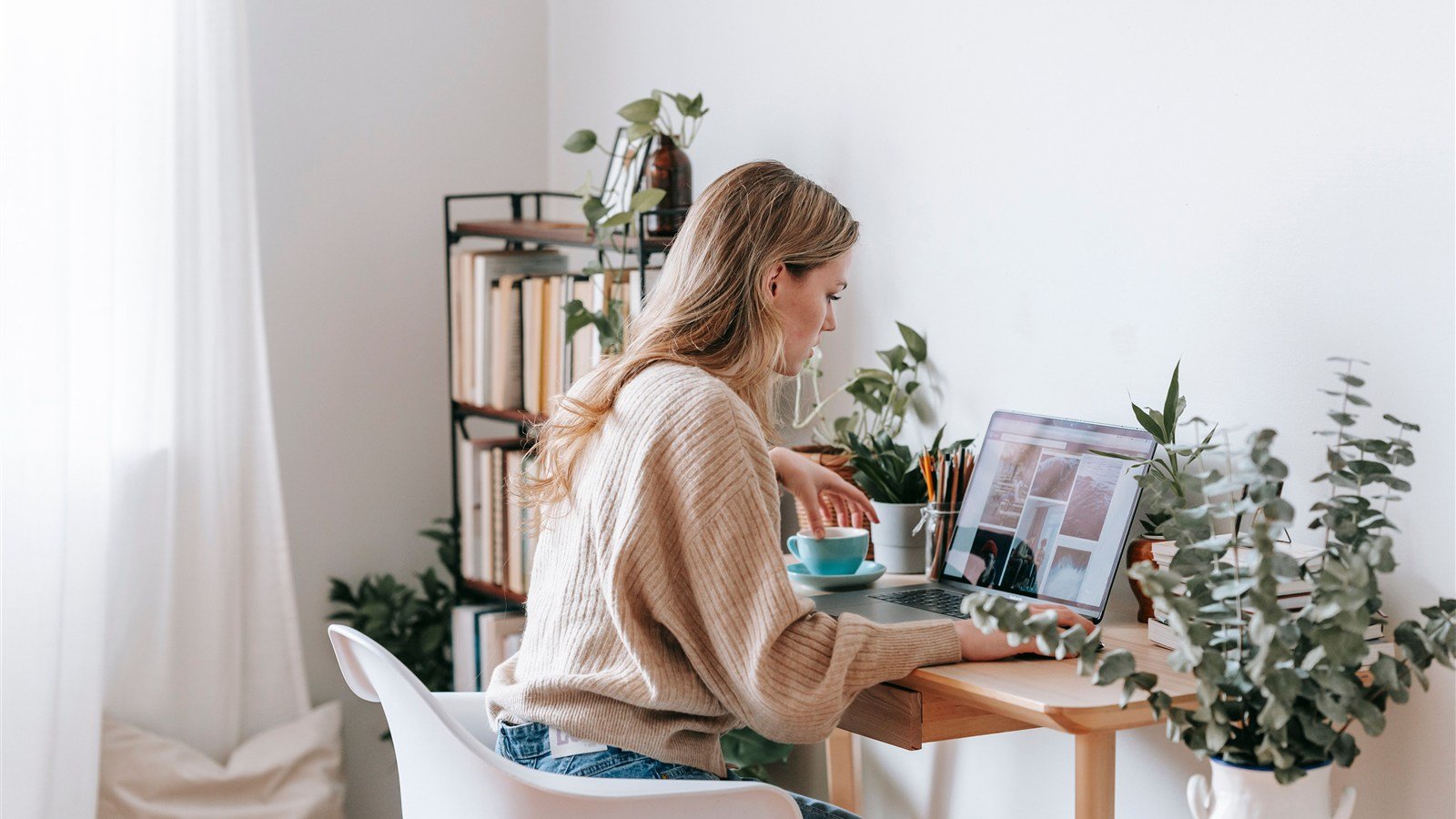 Social media freelancer organizando o calendário de postagens de vários clientes no notebook