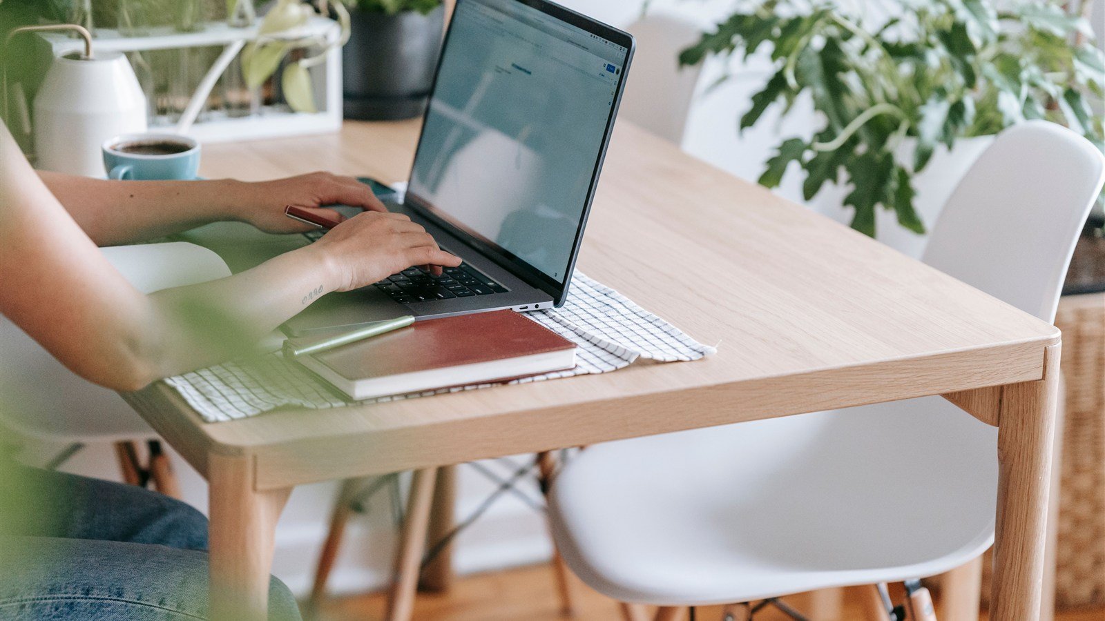 Redatora freelancer escrevendo pauta de conteúdo no notebook em mesa de trabalho