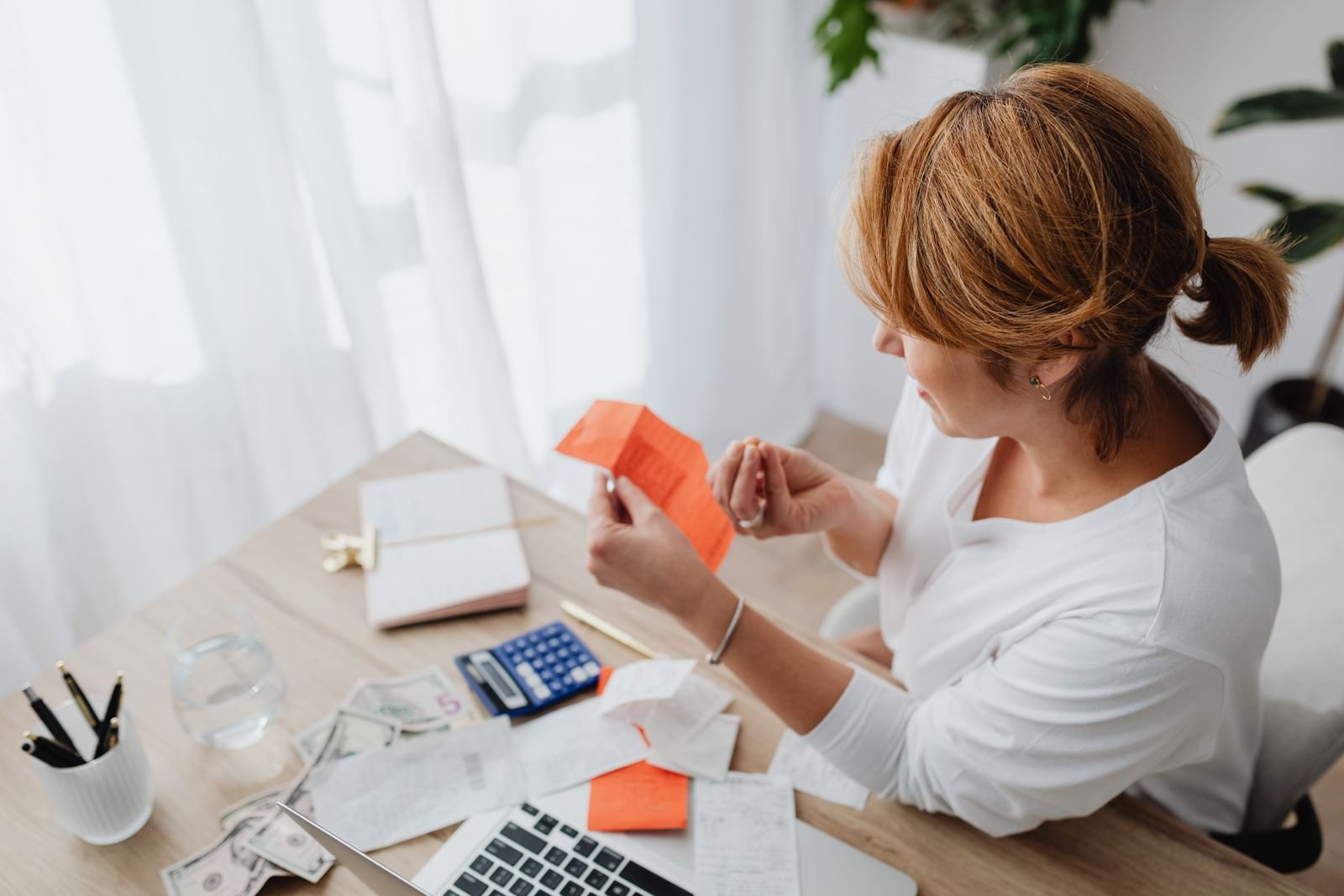 Mulher organizando boletos e contas para conseguir sair das dívidas com renda instável