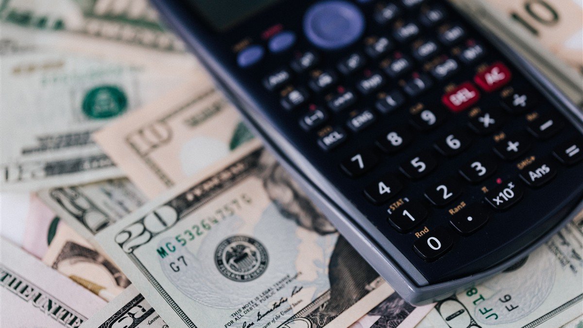 Tradutora freelancer receber em dólar conferindo cotação do câmbio no notebook