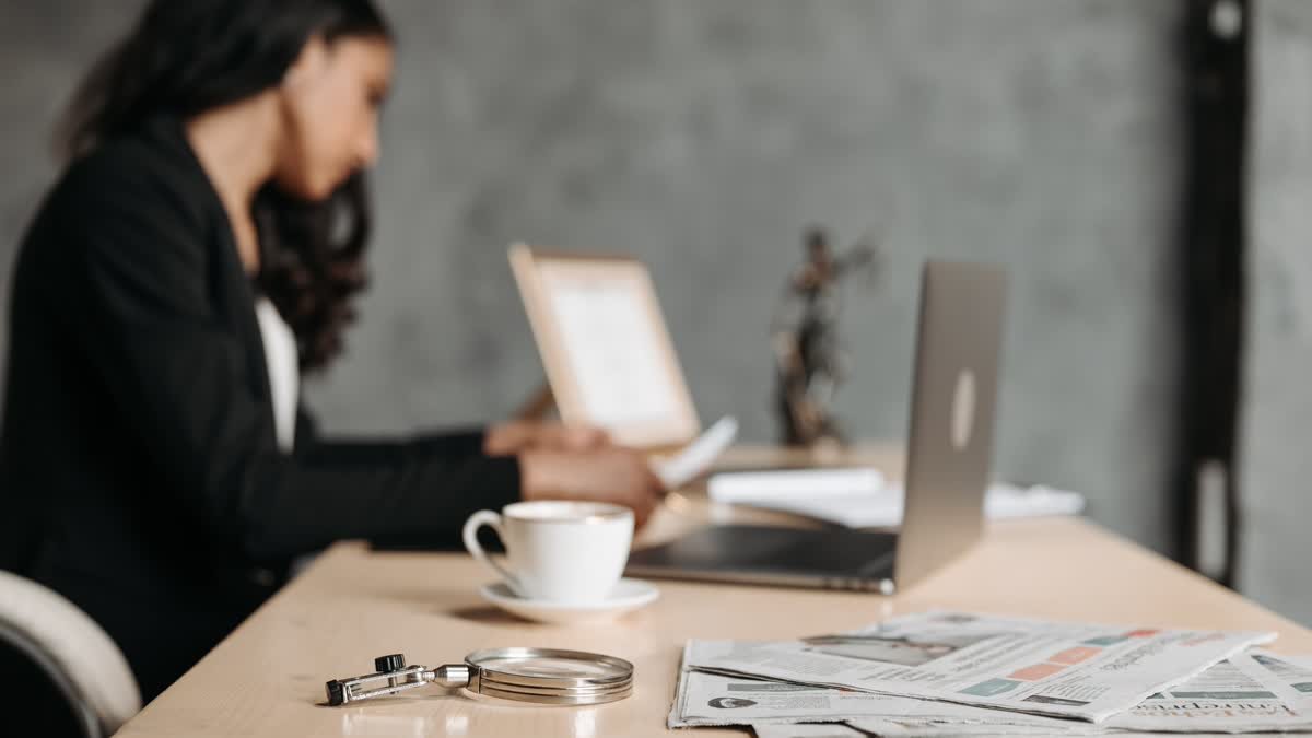 Quanto ganha um corretor de seguros autônomo: corretora conferindo carteira de clientes no notebook
