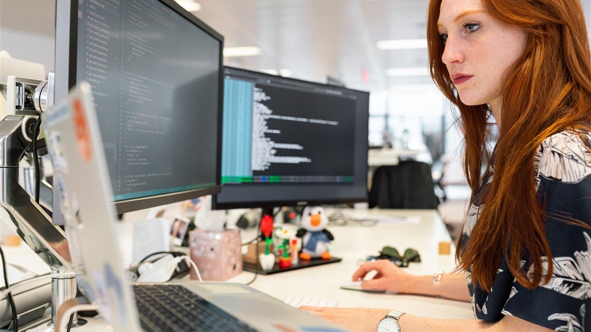Desenvolvedora programando no notebook em mesa de trabalho